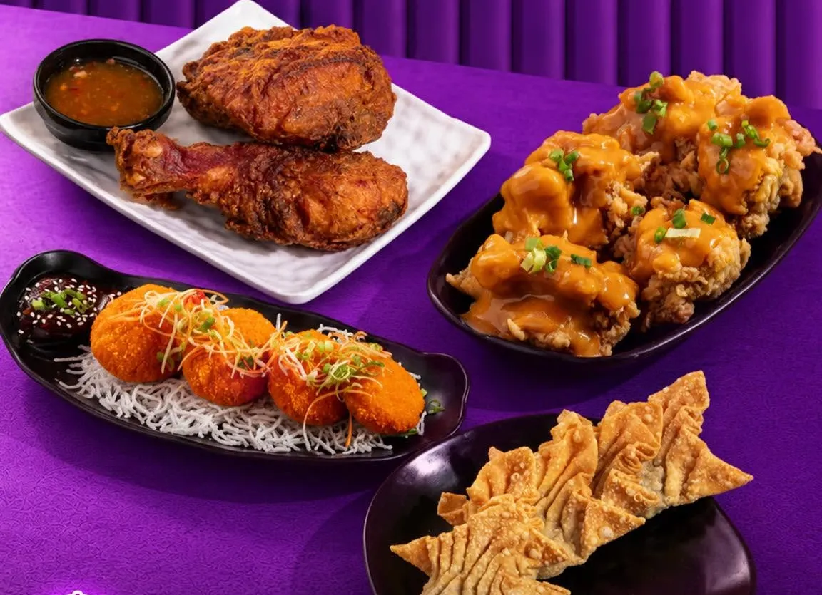 Fried chicken, chicken nanban, shrimp cakes and wontons on a purple table.