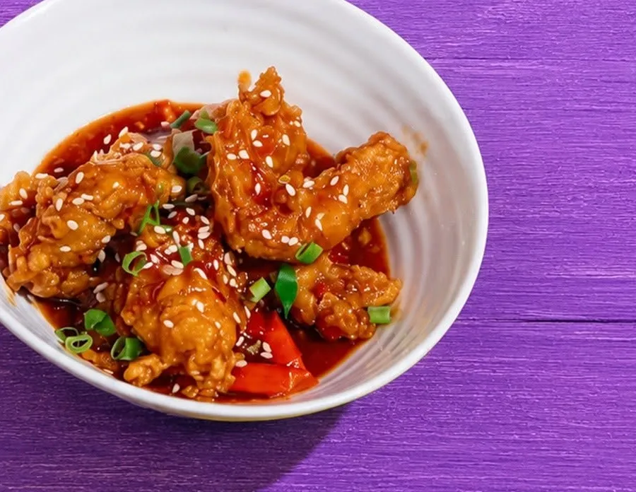 Soy honey garlic prawns with sesame in a white bowl.