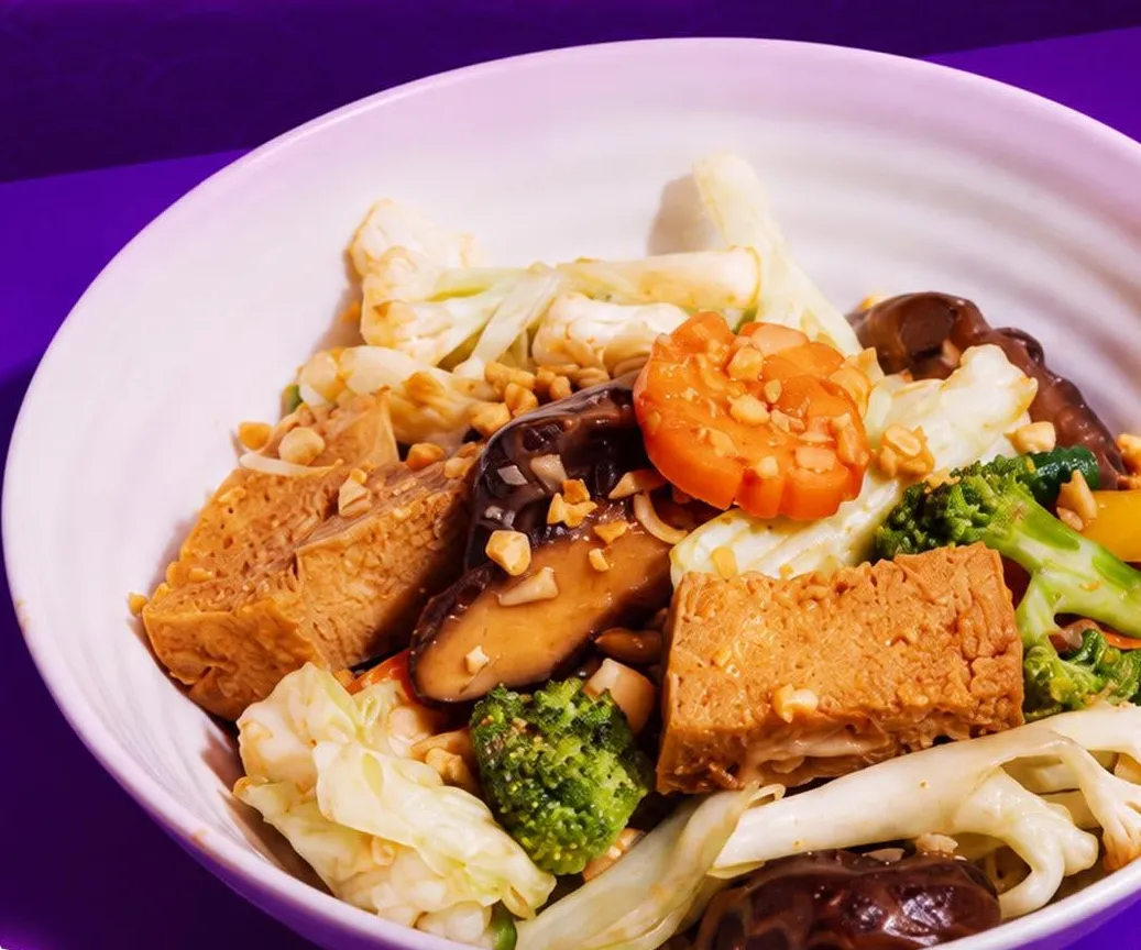 Stir fried vegetables, mushrooms and tofu in a white bowl.